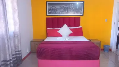 a bedroom with a bed with red and yellow walls at Neo & Ruks excellent Rooms in Goodwood