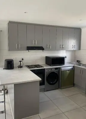 a kitchen with a stove and a dishwasher at Sunbird Poolhouse in Silver Sands