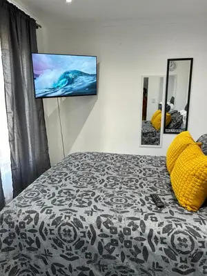 a bedroom with a bed with a flat screen tv on the wall at Sunbird Poolhouse in Silver Sands