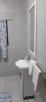 a white bathroom with a sink and a mirror at RoomIsGood in Cape Town