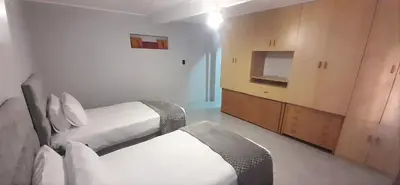 a hotel room with two beds and a television at RoomIsGood in Cape Town