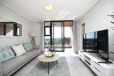 a living room with a couch and a tv at Family Suite-Two Bedroom Waters Edge in Cape Town