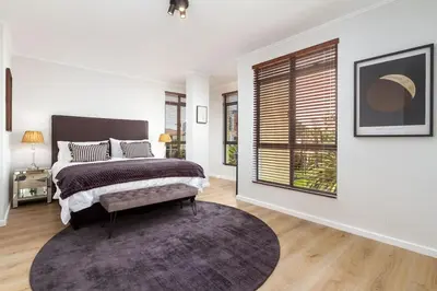a bedroom with a bed and a large window at Luxurious Palm View Apartment Cape Town in Cape Town
