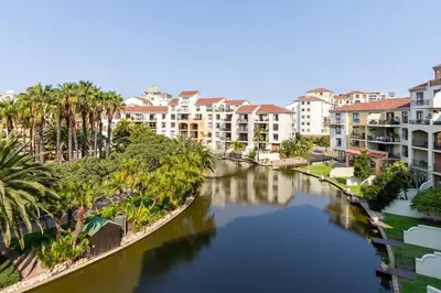 a river in a city with buildings and a canal at Luxurious Palm View Apartment Cape Town in Cape Town