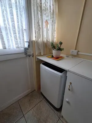 a kitchen with a small refrigerator and a window at Deo Volente Self-Catering Cottage in Kuilsrivier