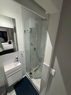 a bathroom with a glass shower and a sink at DRJ Luxe Table view in Table View