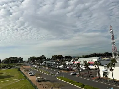 a street with cars parked on the side of a road at DRJ Luxe Table view in Table View