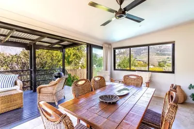 a living room with a wooden table and chairs at Franschhoek Charm in Franschhoek