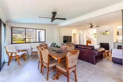 a living room with a table and a couch at Franschhoek Charm in Franschhoek
