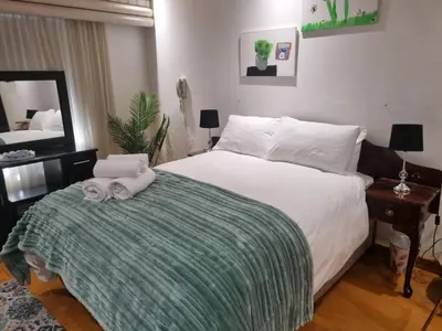 a bedroom with a bed with towels on it at TwinPalace in Plattekloof