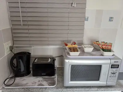 a kitchen counter with a microwave and a toaster at Cozy Cove in Cape Town