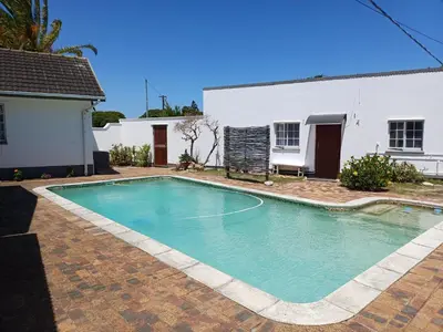 a swimming pool in front of a house at Cozy Cove in Cape Town