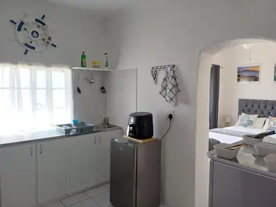 a kitchen with a sink and a bed in a room at Cozy Cove in Cape Town