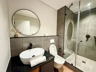 a bathroom with a sink and a toilet and a mirror at Luxe 1br apartment on Park in Cape Town