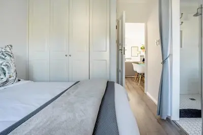 a bedroom with a bed and a bathroom at Tram View Hideaway in Franschhoek