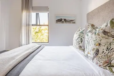 a bed in a room with a window at Tram View Hideaway in Franschhoek