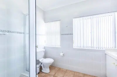 a white bathroom with a toilet and a shower at Akasia 1 in Caledon