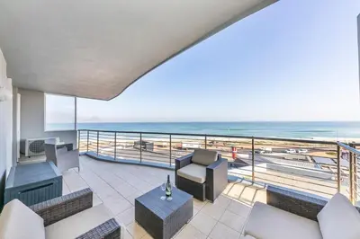 a balcony with a view of the beach at Horizon Bay 201-Beachfront Gem Table Mtn in Cape Town