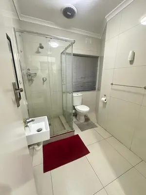 a bathroom with a shower and a toilet and a sink at Surrey B&B in Surrey Estate