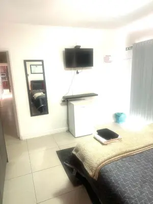 a bedroom with a bed and a television on the wall at Surrey B&B in Surrey Estate