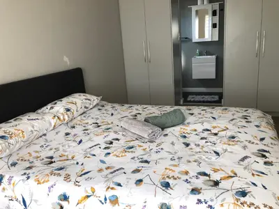 a bed with a floral comforter and pillows on it at Cape on Porterfield in Cape Town