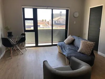 a living room with a couch and a table at Cape on Porterfield in Cape Town