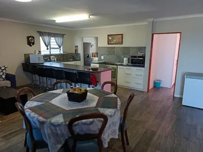 a kitchen and dining room with a table and chairs at Bluehaven self-catering guesthouse in Hermanus