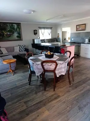 a kitchen and living room with a table and chairs at Bluehaven self-catering guesthouse in Hermanus