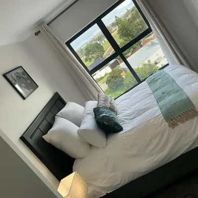 a bed in a room with a large window at DRJ Luxe in Cape Town
