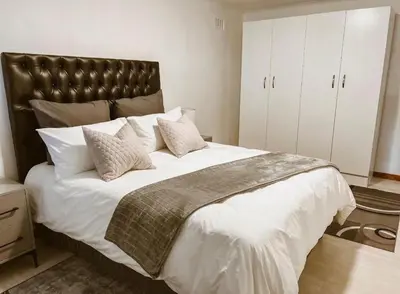 a bedroom with a large bed with a leather headboard at 4 Jooste Street in Windsor Park