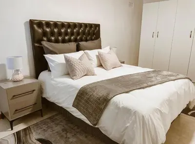 a bedroom with a large bed with white sheets and pillows at 4 Jooste Street in Windsor Park