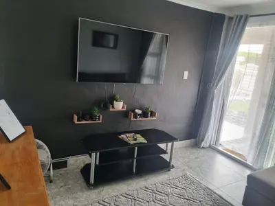 a black living room with a table and a tv at 4 Jooste Street in Windsor Park
