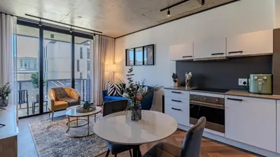 a kitchen and living room with a table and chairs at The Bridgewater collection 411 in Cape Town