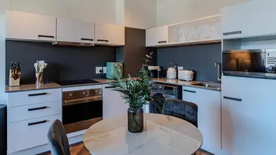 a kitchen with a table with a vase of flowers on it at The Bridgewater collection 411 in Cape Town