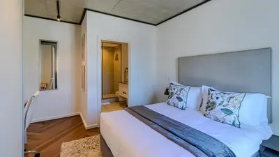 a bedroom with a large white bed with pillows at The Bridgewater collection 411 in Cape Town