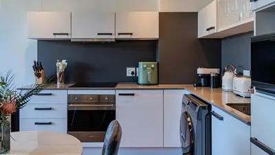 a kitchen with white cabinets and a table at The Bridgewater collection 411 in Cape Town