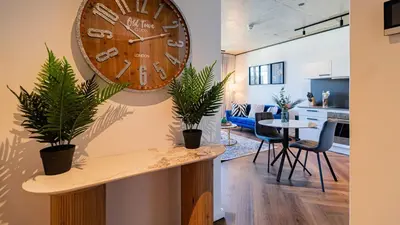 a large clock hanging on a wall with plants at The Bridgewater collection 411 in Cape Town