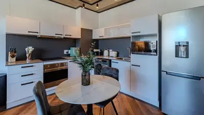 a kitchen with a table with a vase of flowers on it at The Bridgewater collection 411 in Cape Town