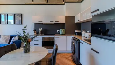 a kitchen with a table and chairs in a room at The Bridgewater collection 411 in Cape Town
