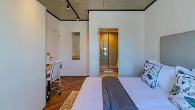 a room with a bed and a desk in it at The Bridgewater collection 411- Luxury 1 bed Morden Apartment at Century City in Cape Town