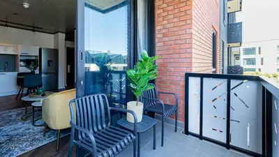 a balcony with chairs and a plant on it at The Bridgewater collection 411- Luxury 1 bed Morden Apartment at Century City in Cape Town