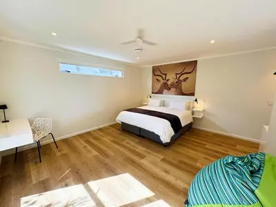 a bedroom with a bed and a desk and a table at Peach On Beach Boutique Apartments in Hermanus
