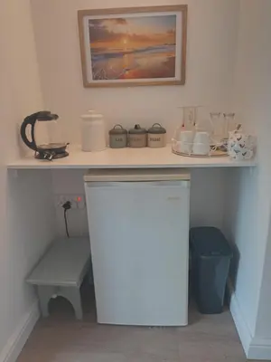 a kitchen with a counter with a shelf and a refrigerator at Mountain View in Hermanus