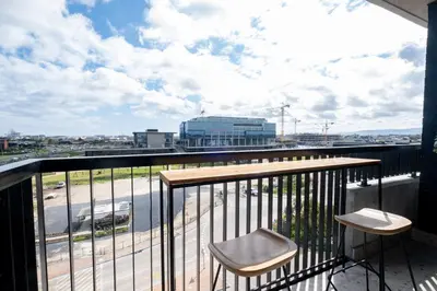a balcony with two stools and a view of a city at 507 Riverlands - Lux Studio Apartment in Cape Town