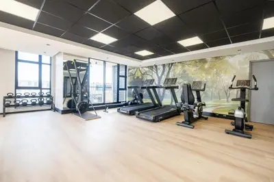 a gym with treadmills ellipticals and a mural at 507 Riverlands - Lux Studio Apartment in Cape Town