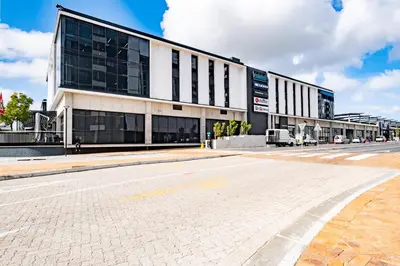 an empty street in front of a large building at 507 Riverlands - Lux Studio Apartment in Cape Town