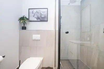 a bathroom with a shower and a toilet and a sink at 705 Riverlands - 1Bedroom Apartment with Mountain Views in Cape Town
