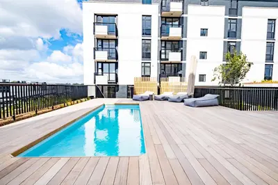 a swimming pool on a deck in front of a building at 705 Riverlands - 1Bedroom Apartment with Mountain Views in Cape Town