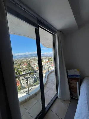 a bedroom with a large window with a view of a city at A little heaven in Strand