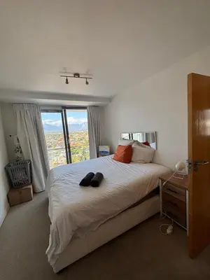 a bedroom with a large bed with a large window at A little heaven in Strand